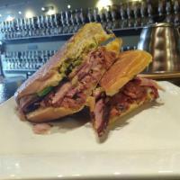 Cuban Sandwich · Carnitas slow cooked in banana leaves, ham, bacon, provolone cheese, pickled jalapenos, our ...