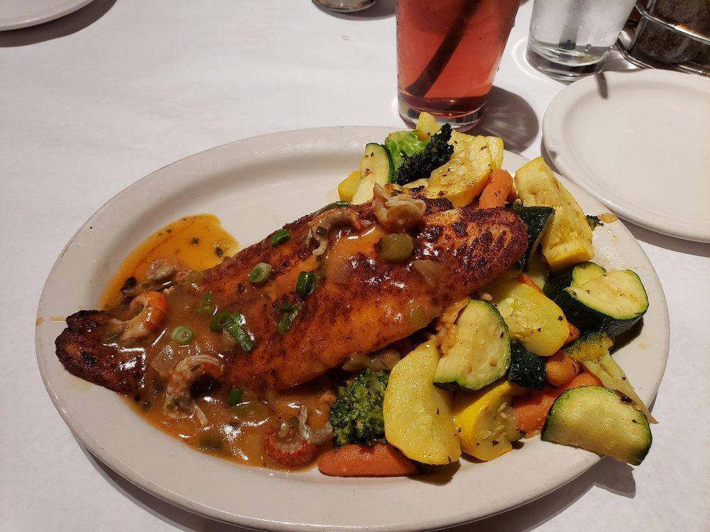 Black Magic Catfish · Blackened catfish smothered in our crawfish étouffée with dirty rice and seasonal vegetables.