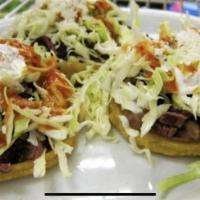 Sopes · Handmade corn tortilla, beans, choice of meat, lettuce, queso fresco, sour cream and salsa.