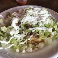 Sope · Handmade thick corn tortilla with refried beans, lettuce, sour cream, fresh cheese and meat ...