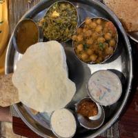 North Indian Thali · Papadam, palak paneer, chana masala, rasam, raita, chapati, basmati rice and kheer.