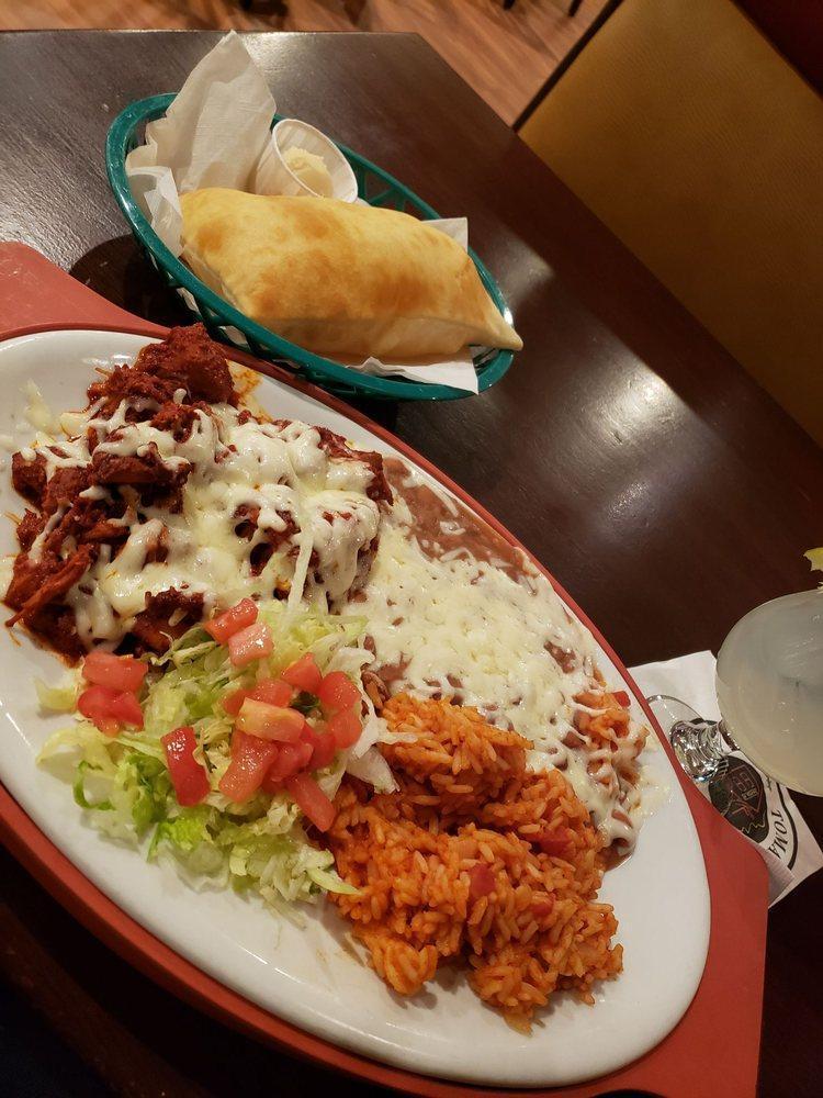Carne Adovada · Marinated pork in a spicy red chile sauce, baked in the oven and covered with cheese. Served with Spanish rice and beans.