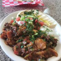 Oqda Lamb · Sautéed meat with vegetables served with a side of pita