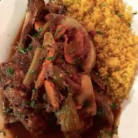 Lamb Shank · Slow-braised lamb shank on the bone topped with celery, potato, carrot, and onion in a tomat...