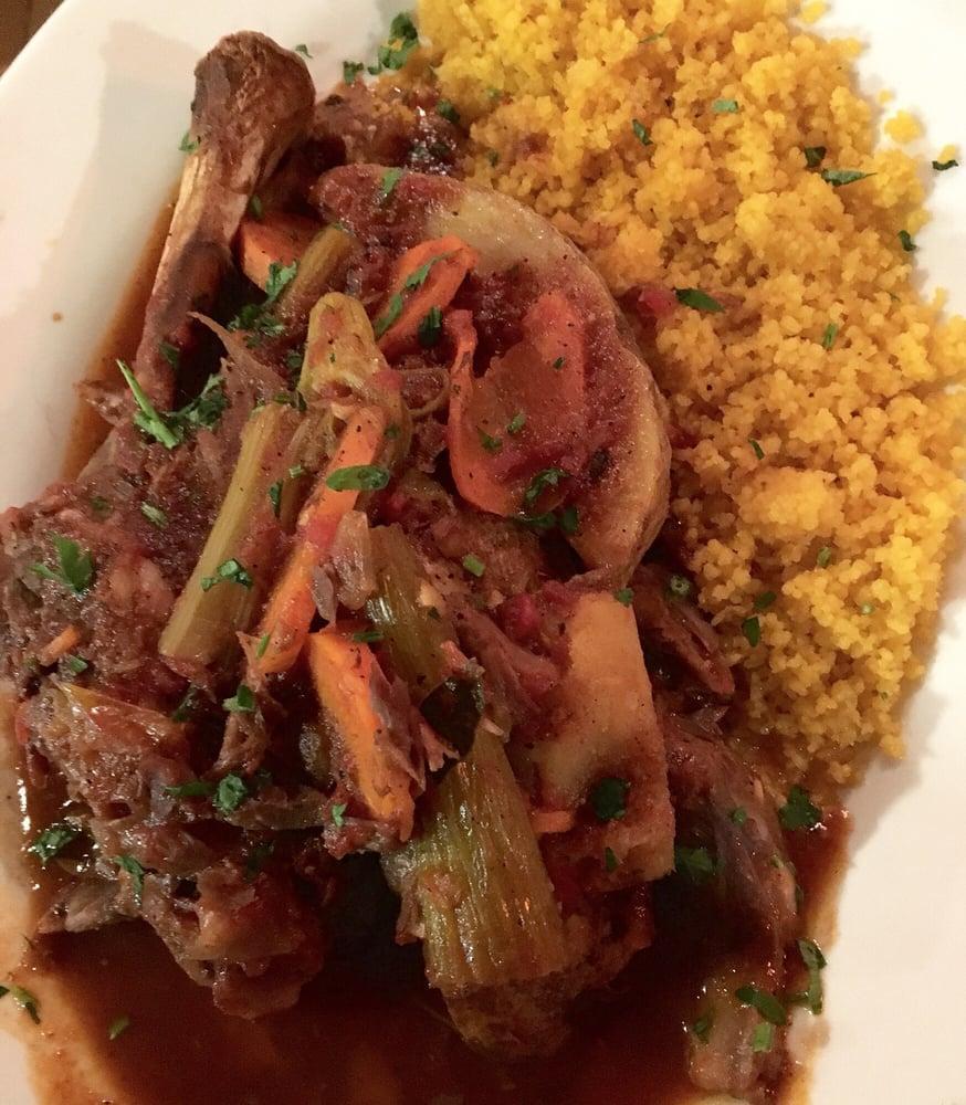 Lamb Shank · Slow-braised lamb shank on the bone topped with celery, potato, carrot, and onion in a tomato sauce. Served with couscous.