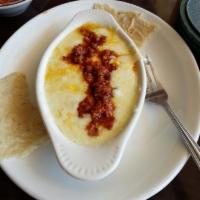 Queso Fundido · Melted monterrey jack cheese topped with chorizo. Served with tortillas.