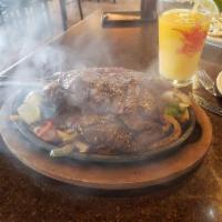 Carne Asada · Grilled outside skirt steak over a bed of onions, green and red bell peppers. Accompanied by...