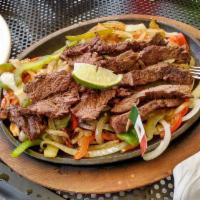 Steak Fajitas · Marinated grilled steak over a bed of grilled onion, green and red bell peppers. Accompanied...