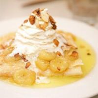 Caramelized Banana · Caramelized bananas atop a crepe filled covered with toasted almonds and finished with powde...