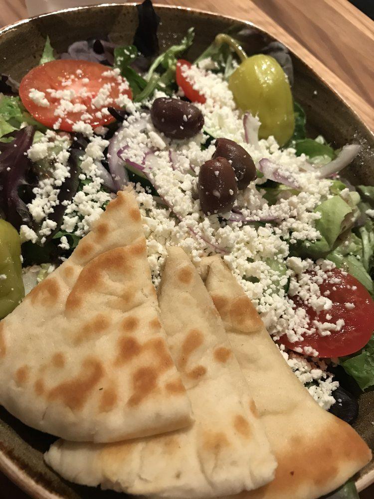 Modern Greek Salad · Lettuce medley, feta cheese, Greek olives, sliced pepperoncini, tomato, cucumber, housemade pickled onions, crispy chickpeas, house vinaigrette (370 cals).  Pita bread (+110 cals).  Add on chilled chopped chicken (+150 cals) or falafel (+250 cals)