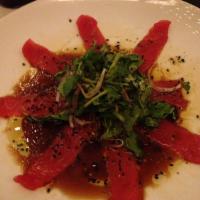 Sashimi Carpaccio · Tuna and salmon, red onion, watercress and ponzu vinaigrette.