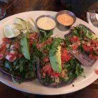 Baja Style Fish Tacos · Three grilled or fried flounder tacos  on blue corn tortilla. Served w/ lettuce, pico de gal...