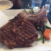 Prime Rib Steak · Bone-in rib steak flame grilled with broccoli, cauliflower and baby carrot sauce side. Serve...