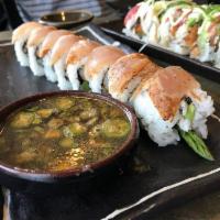 Tsunami Roll · Grilled shrimp, krab, asparagus, avocado, and cucumber layered with Cajun seared albacore, r...