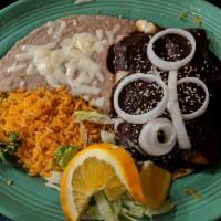 Mole Poblano · Two pieces of chicken topped with thick, rich, chocolate-tinged mole sauce. Garnished with s...