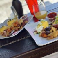 Lobster Benedict · Poached eggs served on an English muffin, topped with Hollandaise and served with trio potat...