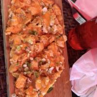 Buffalo Chicken Flatbread · Layered with blue cheese dressing, topped with breaded chicken tossed in buffalo sauce, dice...