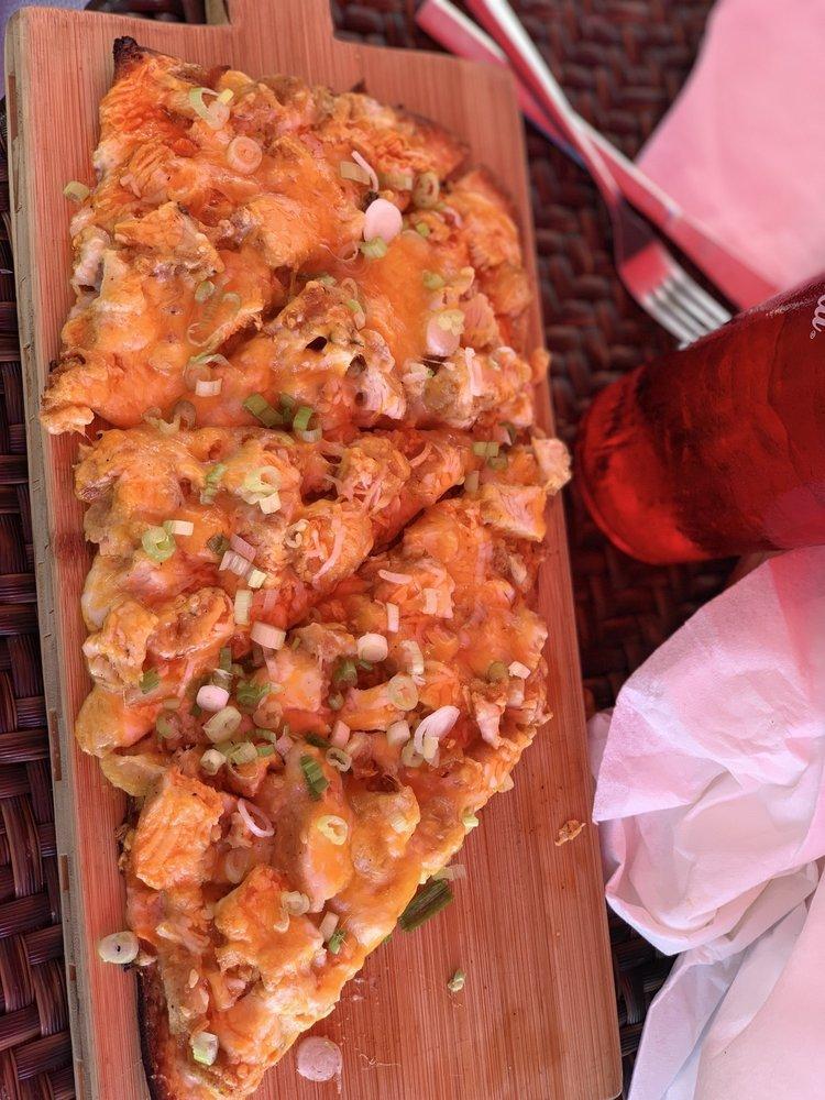 Buffalo Chicken Flatbread · Layered with blue cheese dressing, topped with breaded chicken tossed in buffalo sauce, diced celery and jack cheese and lightly sprinkled with feta cheese crumbles.