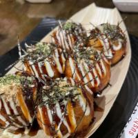 Takoyaki · Japanese fried batter filled with octopus topped with Japanese mayo eel sauce, blue nori  an...