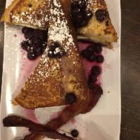 Brioche French Toast · Buttery brioche bread dipped in spiced custard and grilled, finished with powdered sugar. Se...