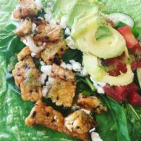 Avocado Tempeh Wrap · Tempeh, avocado, tomatoes, cucumbers, onions, romaine lettuce, spinach, goat cheese, and dri...