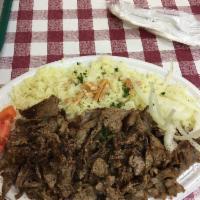 Shawarma · Slices of seasoned beef slowly cooked and skewered. Served with rice, salad, and pita bread.