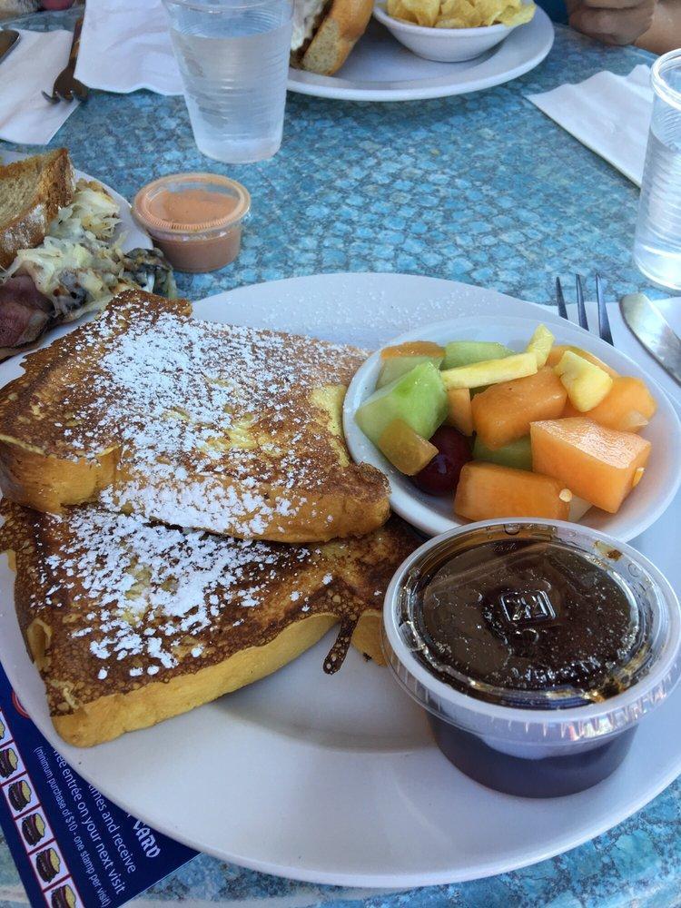 Challah French Toast · Thickly sliced challah dipped in milk, eggs, cinnamon and vanilla, then grilled golden brown. Served with fresh fruit and breakfast syrup.