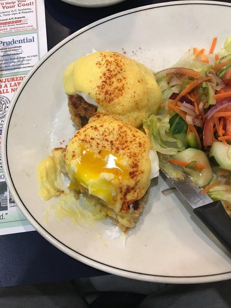 Crab Cake Benedict · Fresh lump crab cakes topped with poached eggs & hollandaise served with fresh garden salad