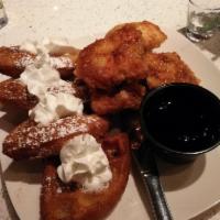 Chicken and Waffles · Tempura style Belgian waffles with crispy boneless chicken served with whipped cream and map...