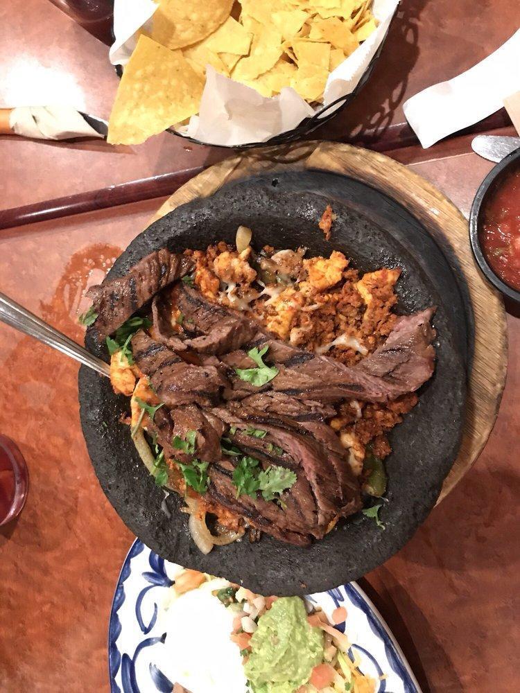 Molcajete · Steak and chicken fajita strips, bell peppers, onions, and chorizo. All covered with Jack cheese and roasted molcajete sauce. Served with pico de gallo, sour cream, and guacamole.
