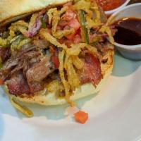Shiner BBQ Brisket Sandwich · Shiner-marinated beef brisket tossed in BBQ sauce and served on a burger bun. Onions and pic...