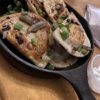 Perogies · Western Canada. Potato and cheese perogies sauteed with onions and bacon served with sour cr...