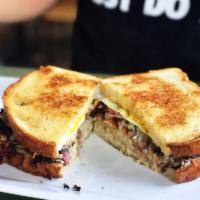 The Pastrami and Egg Sandwich · Pastrami, Swiss cheese, grilled onions, 2 over medium eggs, hash browns and
mustard on grill...