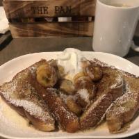 N'awlins Banana Fosters French Toast · 2 batter dipped brioche slices topped with rum caramel sauteed bananas, vanilla butter, powd...