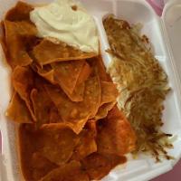 Chilaquiles · Served with beans, rice or hashbrowns .Fried corn tortillas mixed with salsa topped with che...