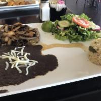 Bistec Encebollado · Steak sauteed with onions and served with rice and beans.