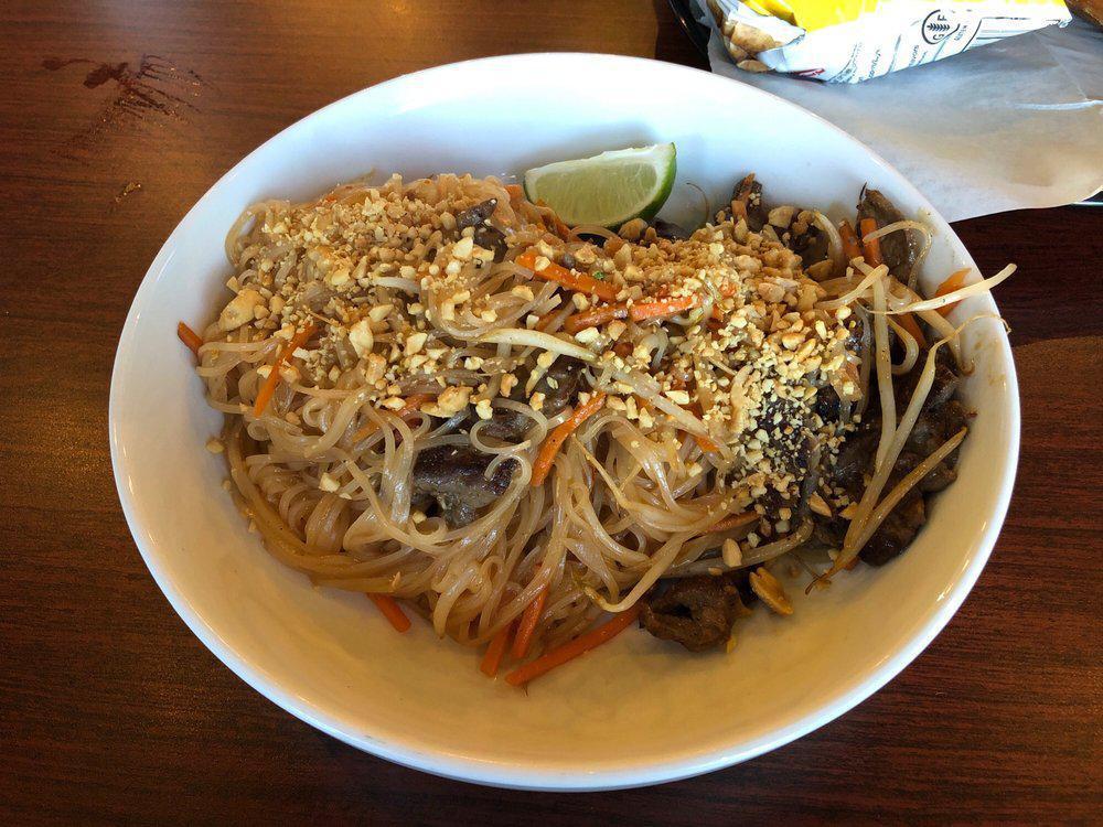 Beef Pad Thai Noodles · Wok tossed rice noodles in a sweet and tangy tamarind sauce with bean sprouts, carrots and onions. Garnished with crushed peanuts, cilantro and lime