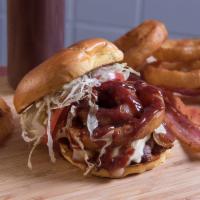 Cowboy Burger · Bacon cheese burger with lettuce, tomato, crispy, battered onion rings on top and BBQ sauce.