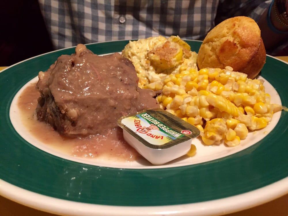 Pot Roast · Tender pot roast topped with brown gravy made from the drippings, blue plate served with 2 sides, and a corn muffin.
