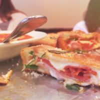 Stromboli · Rolled up dough with mozzarella cheese pepperoni, ham and side of marinara sauce.