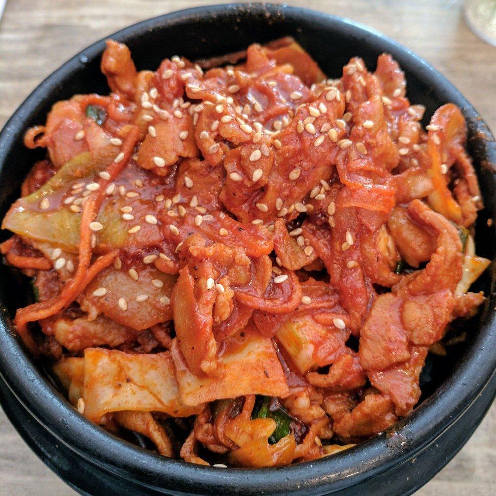 Spicy Pork Shoulder · Thinly sliced pork shoulder, stir-fried with house chili pepper sauce, green cabbage, carrot, scallion, onion and sesame seeds over sticky rice or brown rice.