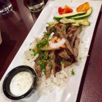 Aladdin's Gyro Platter · Grilled slices of gyro meat on a bed of herb spiced rice with tomatoes, onions, and cucumber...