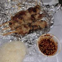 Moo Ping · Thai street food style grilled pork on skewers served with sticky rice and chili tamarind di...