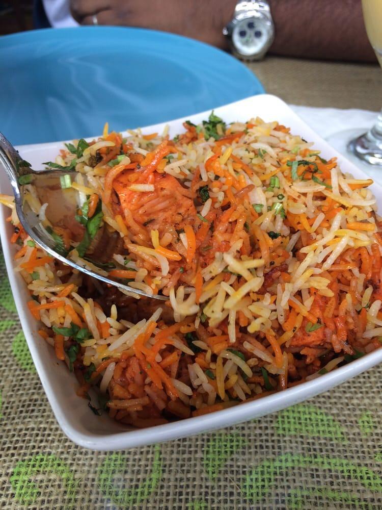 Chicken Biryani · Boneless chicken cooked in aromatic saffron and herb-infused basmati rice, with a side of mint raita. Gluten-free.