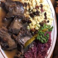 Sauerbraten · Slices of marinated beef smothered in gravy sauce. Served with red cabbage and dumplings.