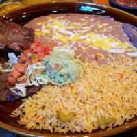 Carne Asada · Skirt steak cooked to your preference served with rice and beans garnished with lettuce, pic...