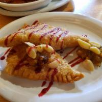 Brie Empanadas · Puff pastry stuffed with brie. Served with roasted garlic, raspberry coulis, and green chile...