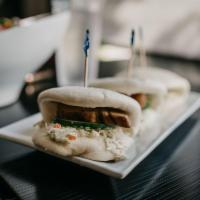 Pork Buns · Steamed wheat buns filled with slices of savory pork belly. Topped with cucumbers, coleslaw,...
