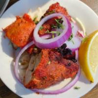 Tandoori Chicken · Chicken on the bone marinated with Indian spices, yogurt, ginger, garlic and grilled in the ...