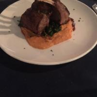 New Zealand Rack of Lamb · Served with chipotle sweet potato puree and wilted spinach and leeks topped with pomegranate...